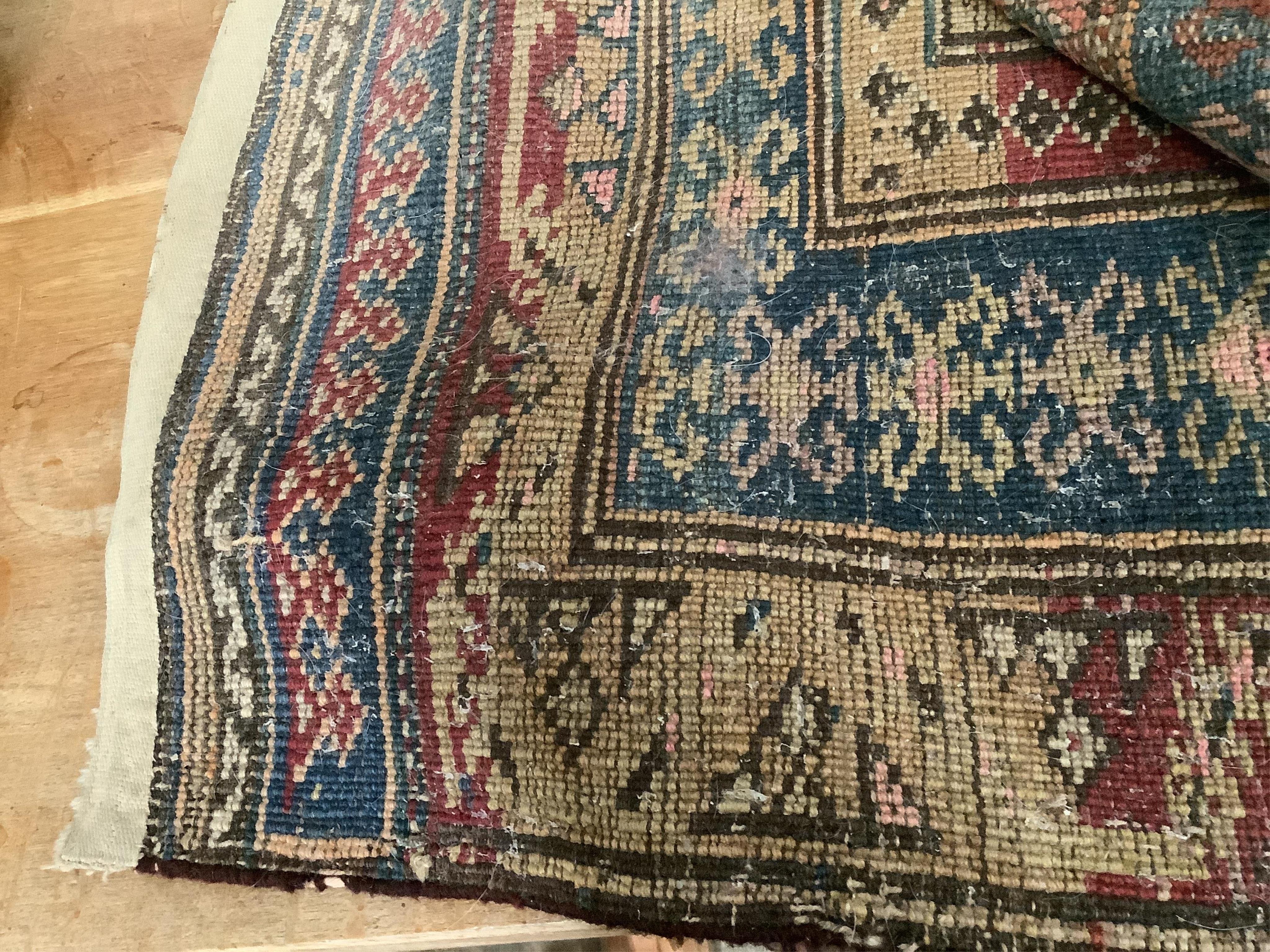 A Caucasian blue ground rug with flower motifs, 180 x 130cm. Condition - fair